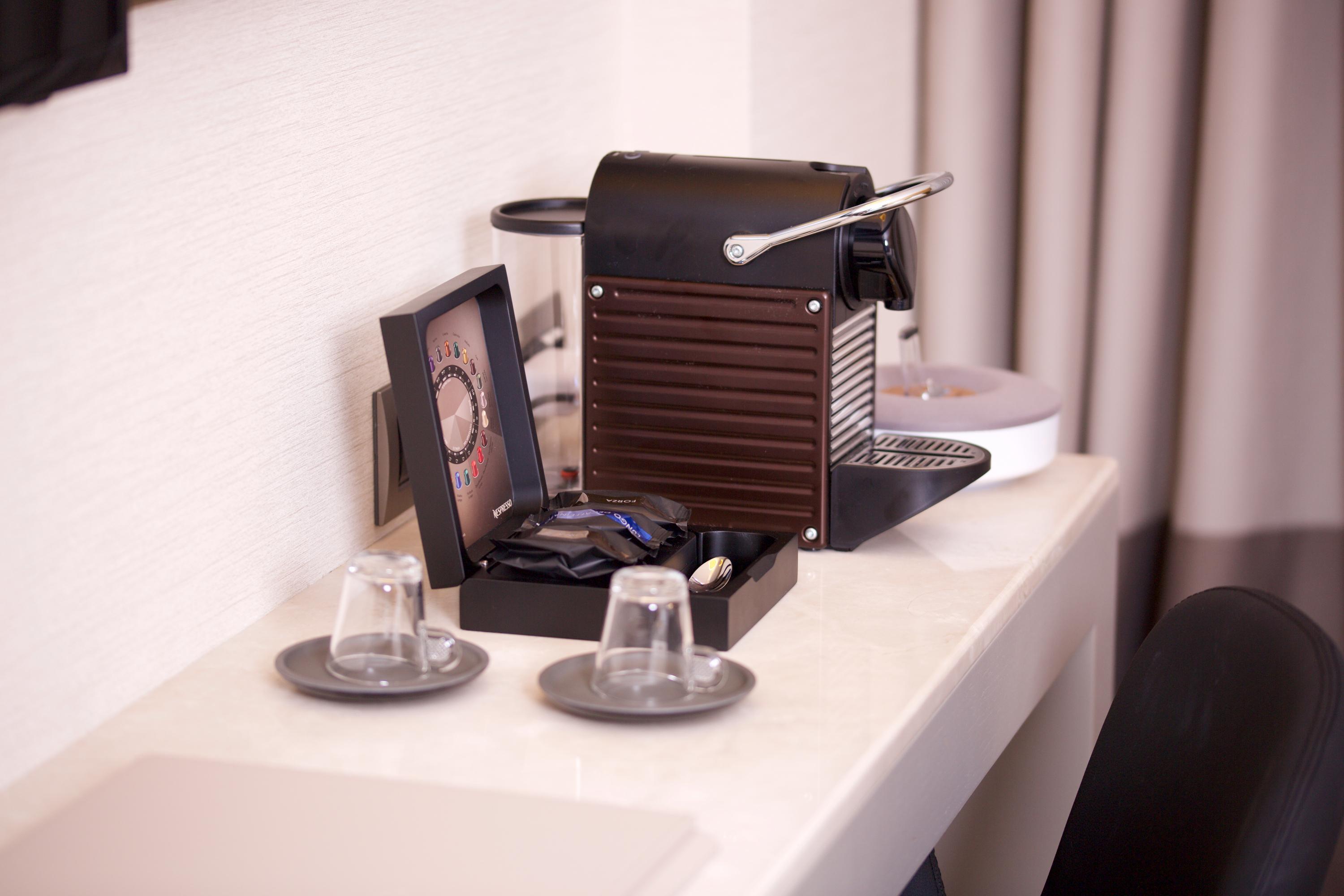 Dosso Dossi Hotels & Spa Downtown Istanbul Ngoại thất bức ảnh The photo shows a coffee machine placed on a light-colored countertop. The machine appears to be a Nespresso-style espresso maker, featuring a sleek, modern design in black. Next to the machine, there is a small decorative box containing coffee pods.