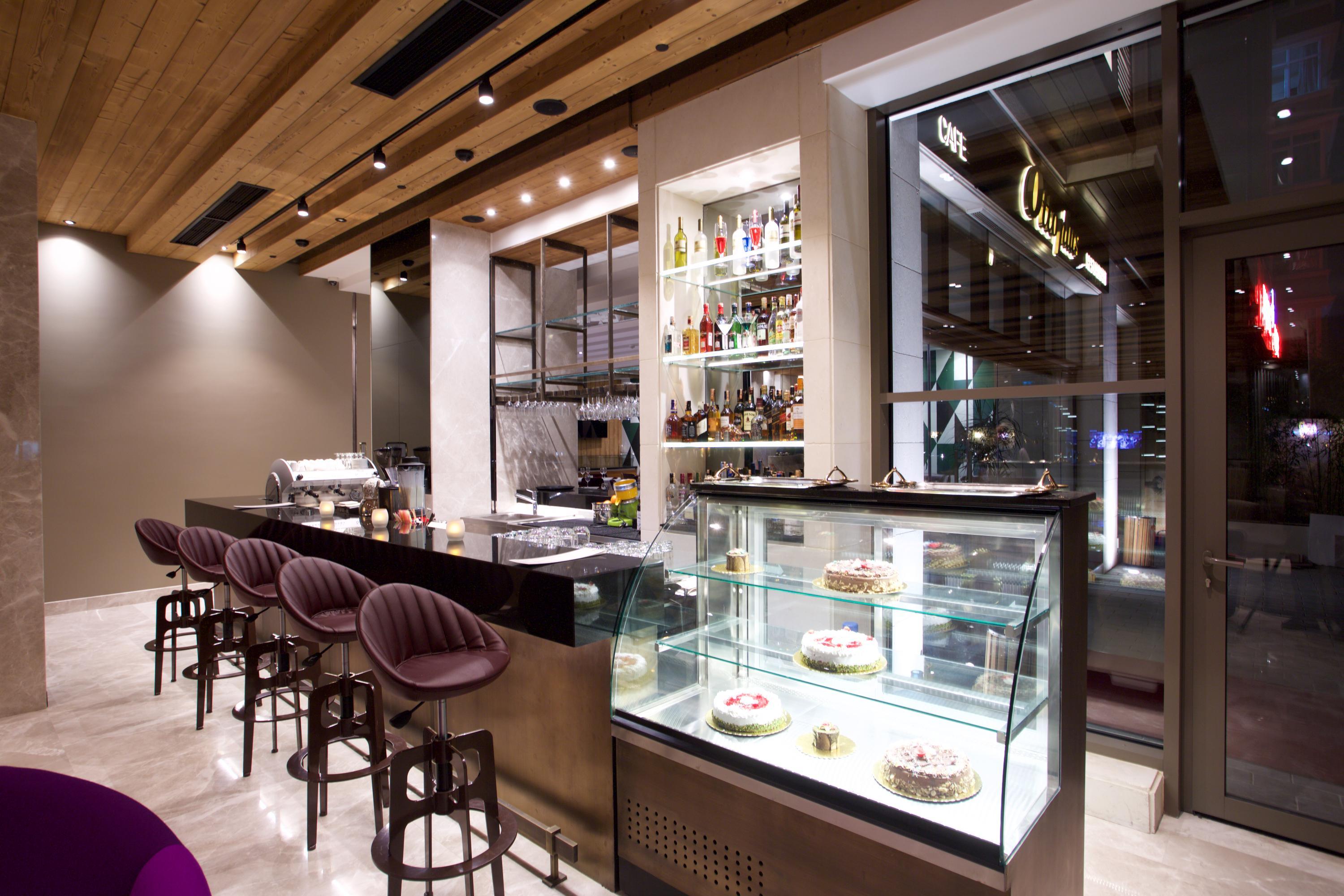 Dosso Dossi Hotels & Spa Downtown Istanbul Ngoại thất bức ảnh The photo shows the interior of a modern restaurant or café. There is a sleek bar area with a few high stools and a polished countertop. Behind the bar, shelves are stocked with various bottles, indicating a selection of drinks. To the right, there's