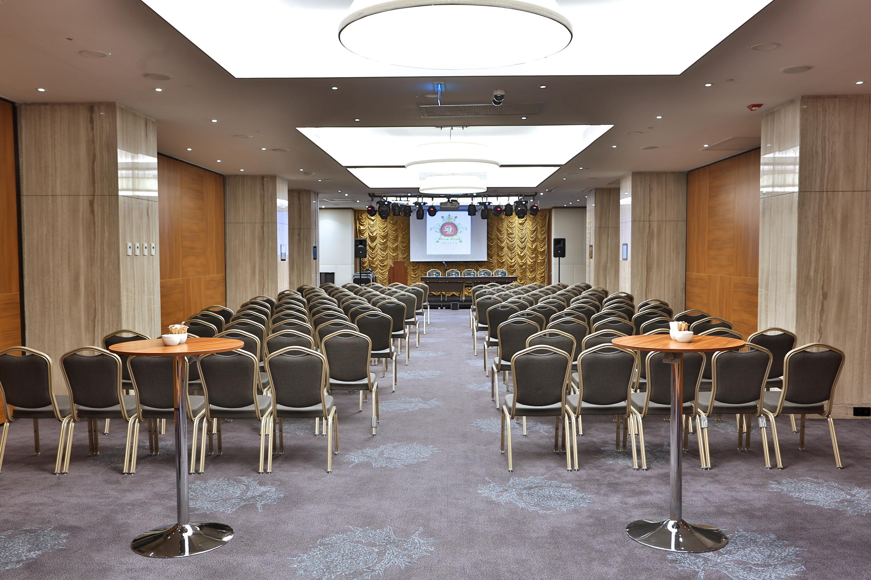 Dosso Dossi Hotels & Spa Downtown Istanbul Ngoại thất bức ảnh The photo shows a spacious meeting or conference room. There are many rows of chairs arranged in a theater-style setup, indicating that it's likely meant for presentations or lectures. In the front of the room, there is a stage or platform area with 