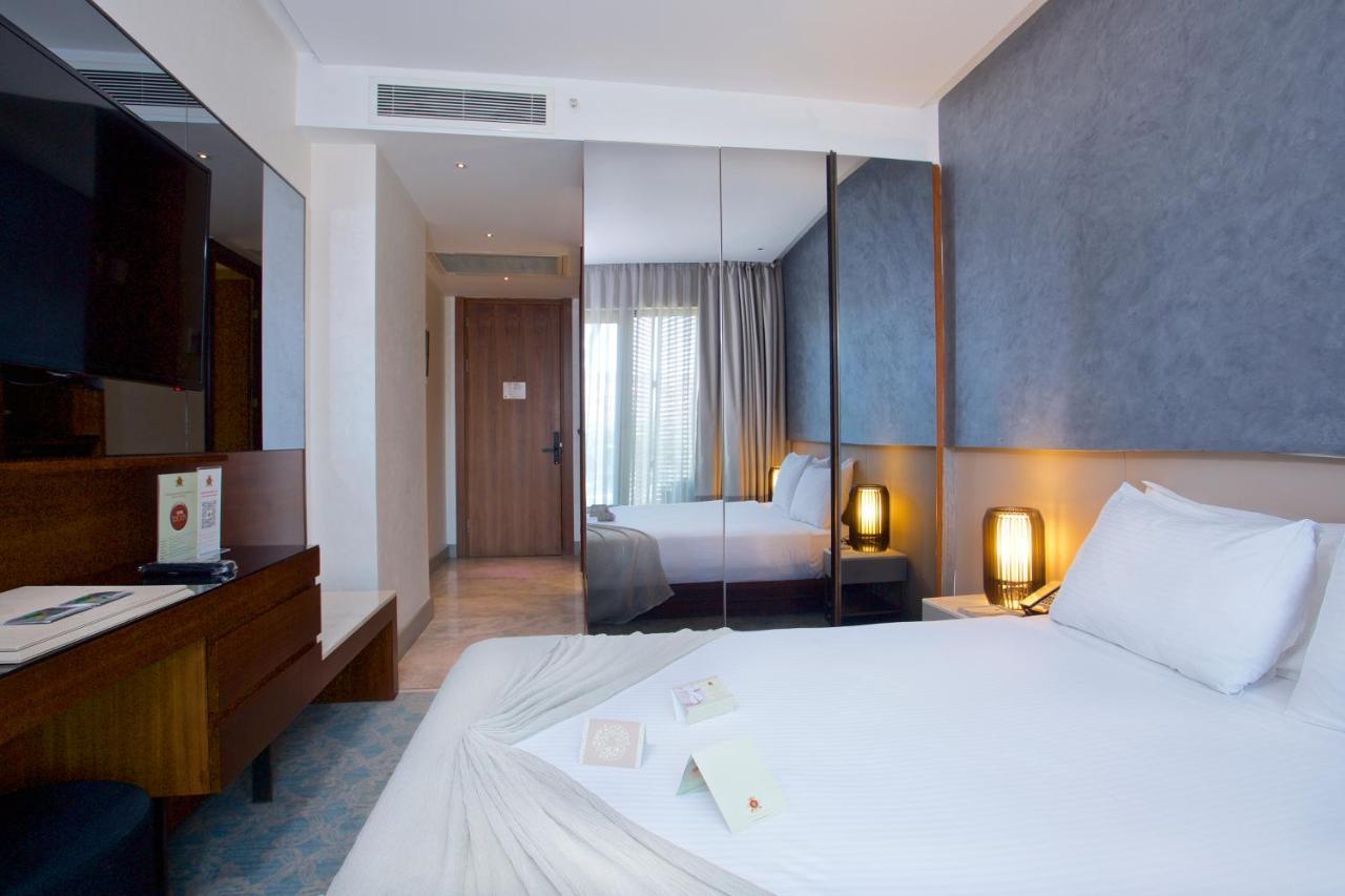 Dosso Dossi Hotels & Spa Downtown Istanbul Ngoại thất bức ảnh The photo shows a modern hotel room. It features a neatly made bed with white linens, and there are decorative items placed on the bed. The room has a contemporary design with light-colored walls and a large window allowing natural light to enter. 

