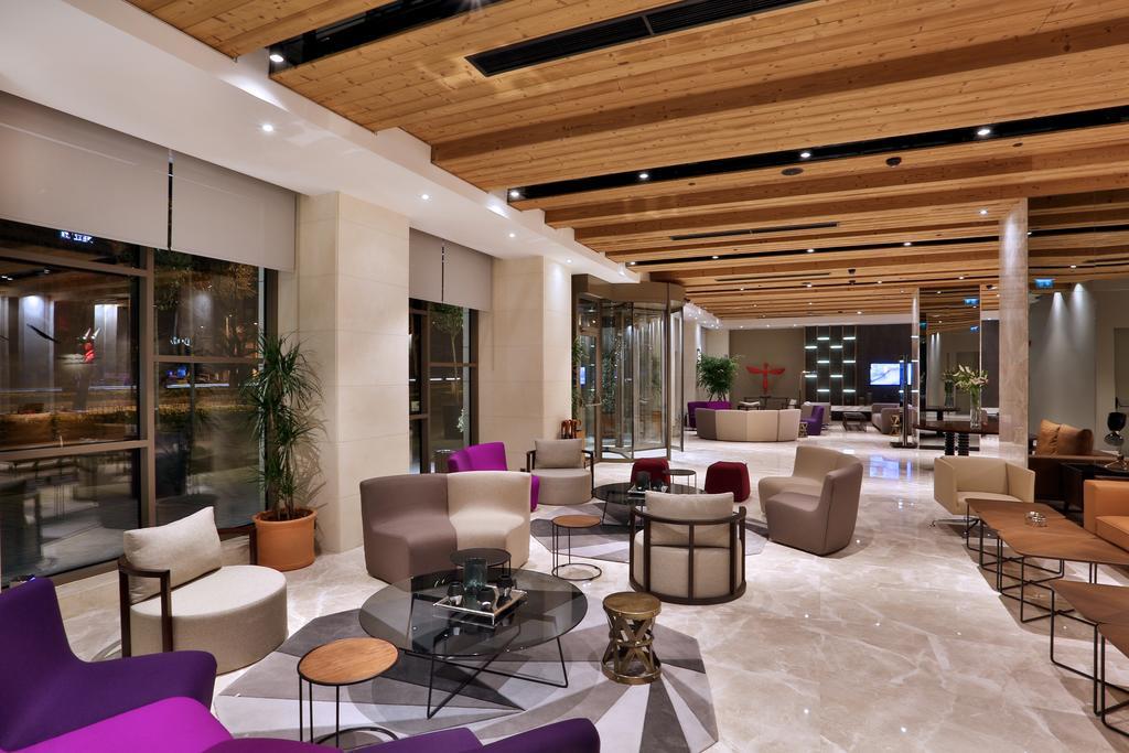 Dosso Dossi Hotels & Spa Downtown Istanbul Ngoại thất bức ảnh The photo shows a modern and stylish lobby or lounge area. It features a combination of comfortable seating options, including a mix of chairs and sofas in various shapes and colors, such as purple and beige. The space is well-lit with natural light 